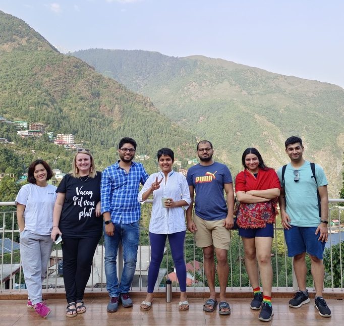The image shows a group of digital nomads in Dharamkot