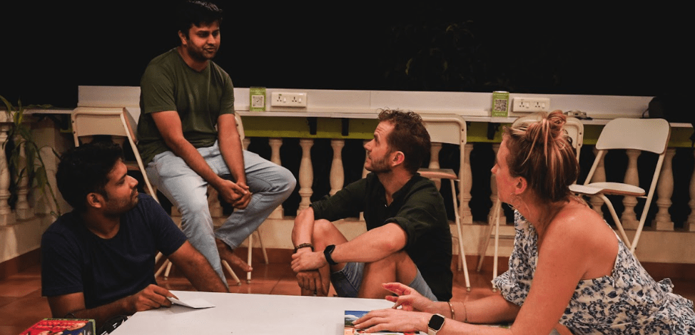 The image shows digital nomads connecting at community events in Goa, India