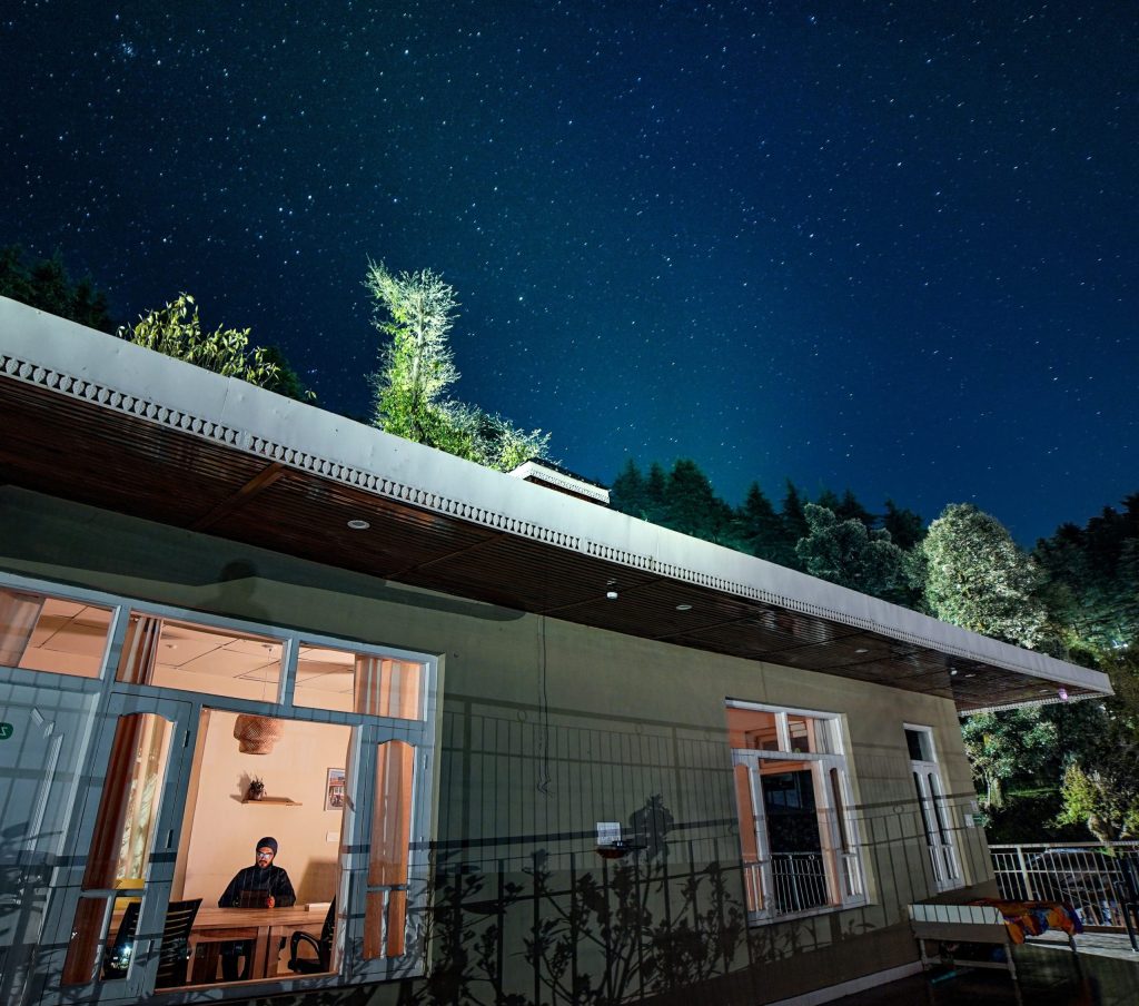 The image shows a coworking space at NomadGao Dharamkot in Himachal Pradesh, India
