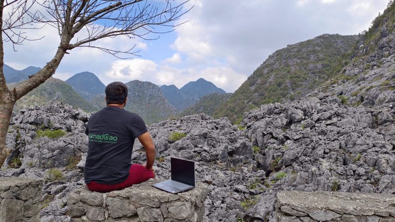 The image shows a digital nomad in the mountains